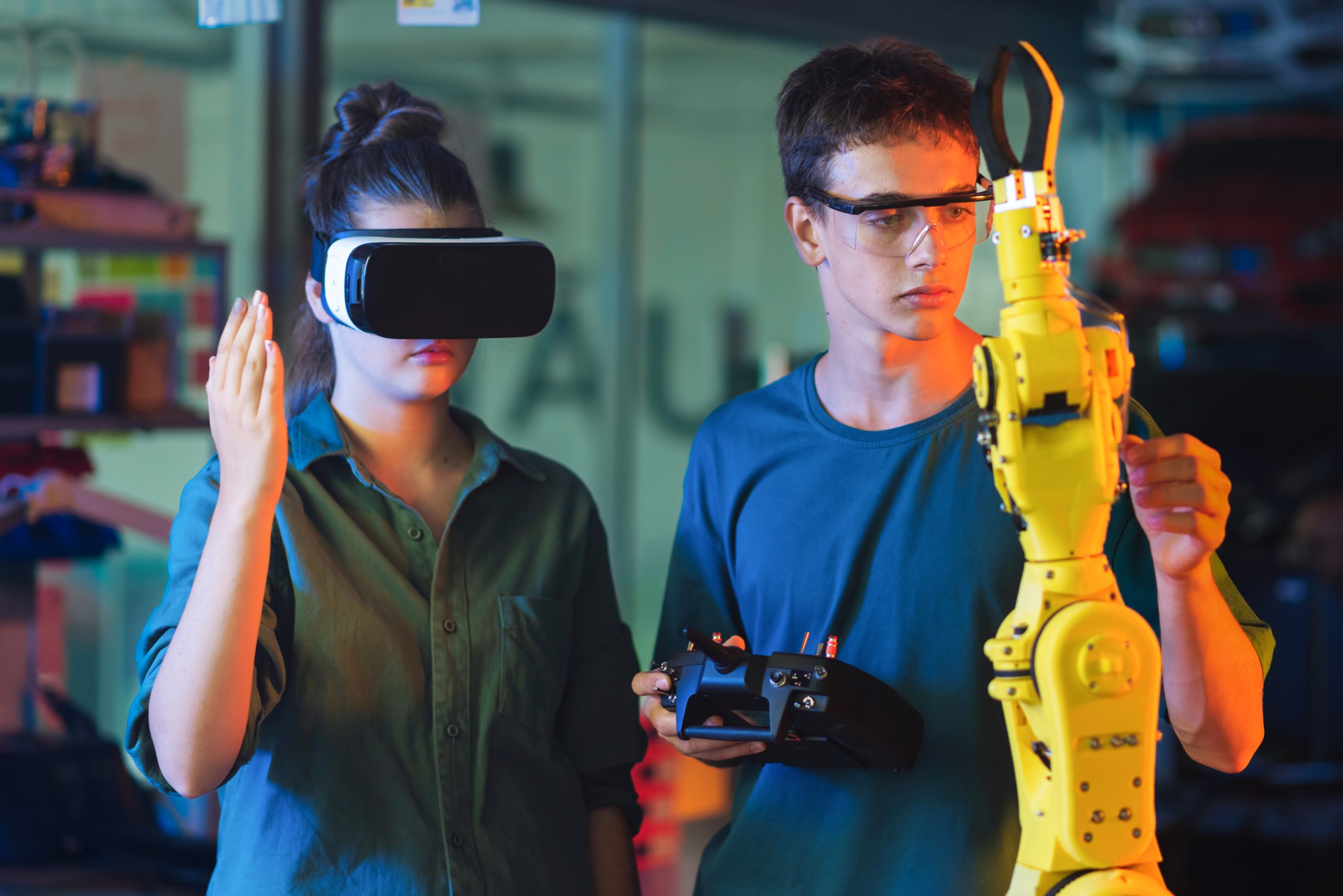 Teens remotely controlling robots in a laboratory Teens remotely controlling robots in a laboratory